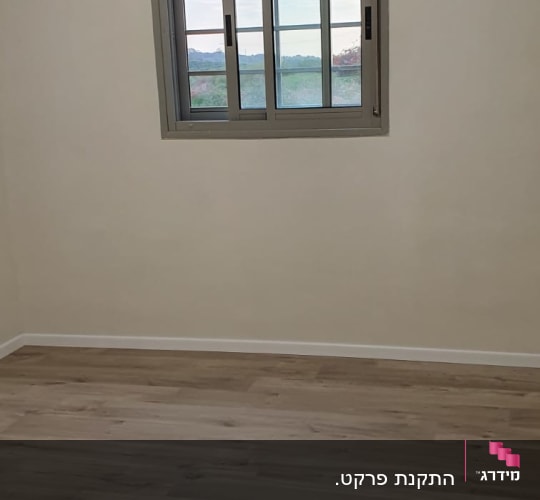 רצפת פרקט עץ בחדר ריק עם חלון